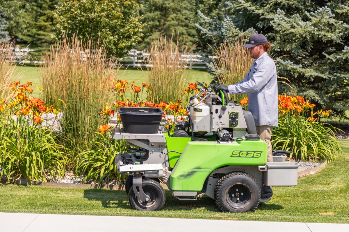 lawn care technician running a sprayer on a nice lawn