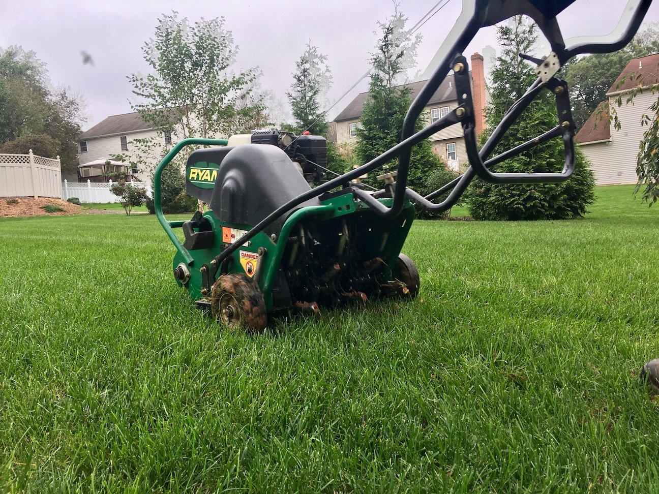 lawn care technician pushing a lawn aerator on a nice idaho falls lawn