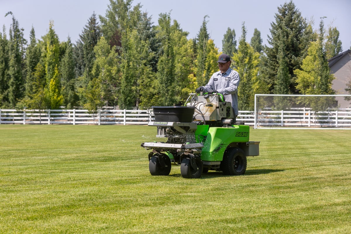 lawn care team member fertilizing a boise lawn